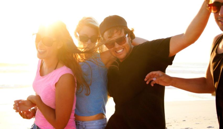 A group of friends dancing on the beach.