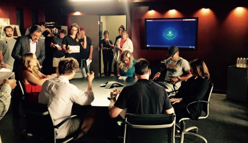 A group of people sitting around a table in a conference room.