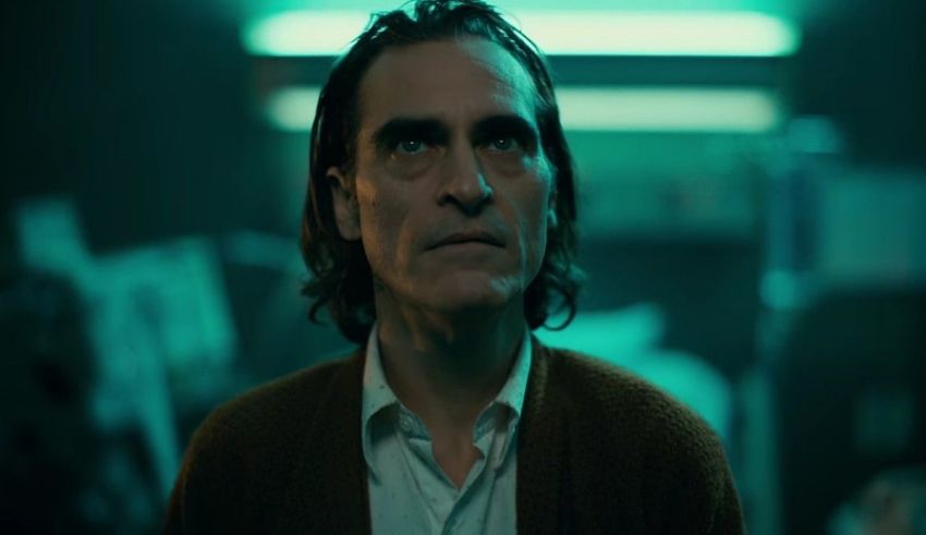 A man with long hair standing in a dark room.