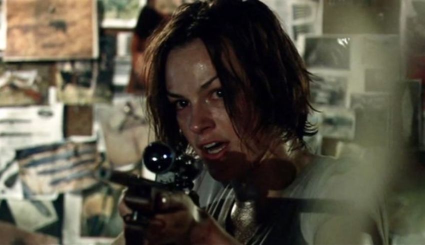 A woman holding a gun in a room.