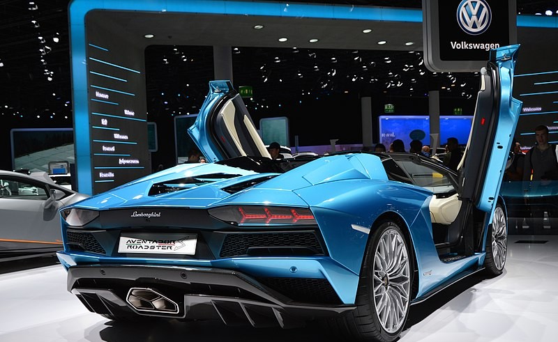 A blue sports car is on display at an auto show.