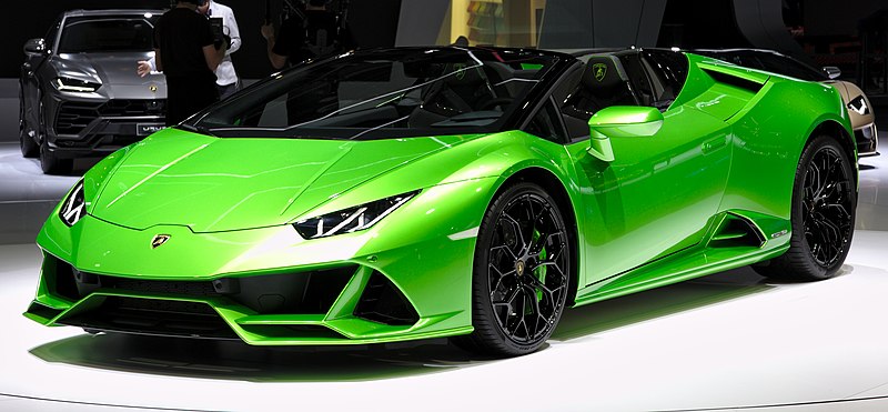A green sports car is on display at an auto show.
