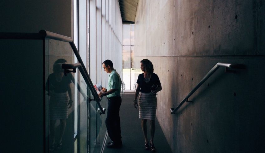 Two business people standing on a stairway.