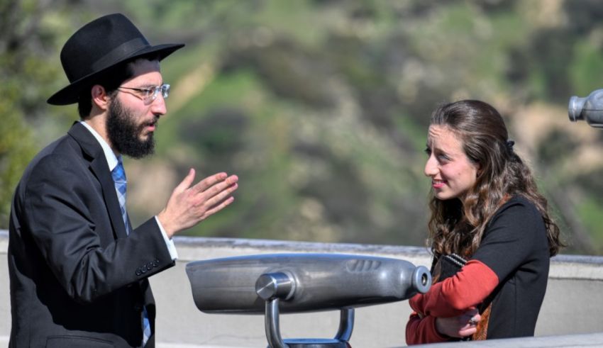 A man in a hat and a woman in a hat talking to each other.