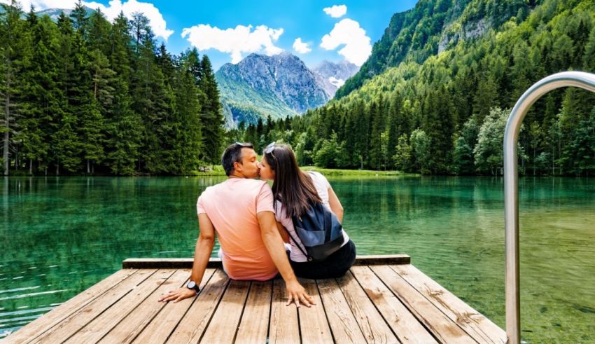 A couple sitting on a dock overlooking a lake.