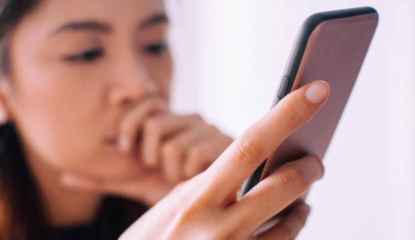 A woman is looking at her cell phone.