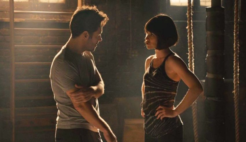 A man and woman standing next to each other in a dark room.