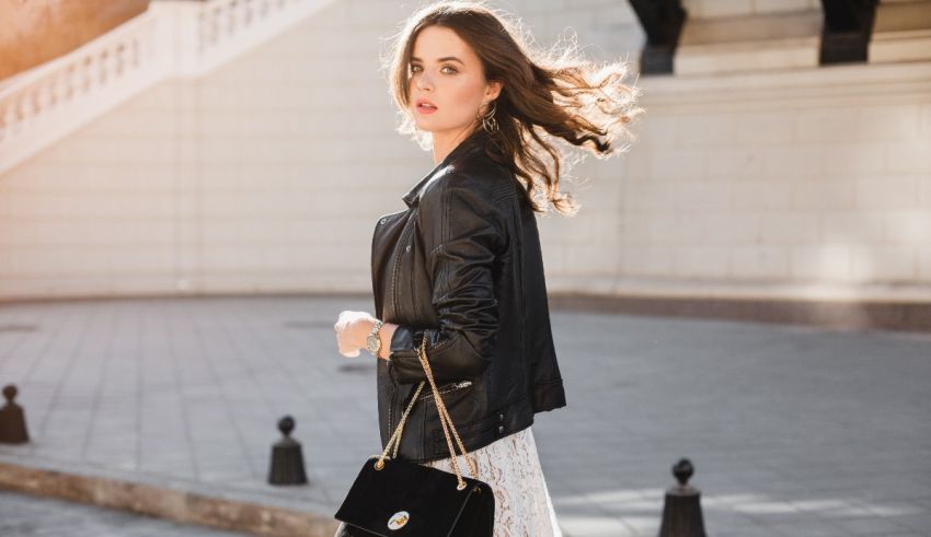 A woman wearing a black leather jacket and a white lace dress.