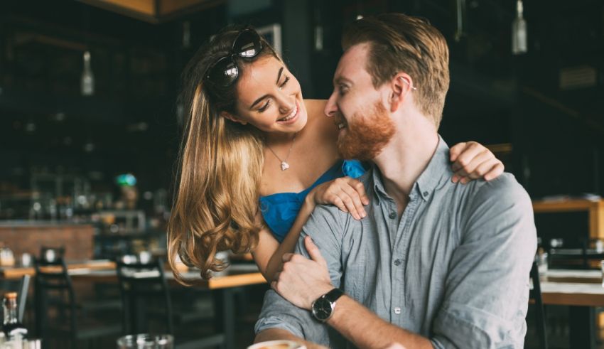 A man and woman hugging in a restaurant.