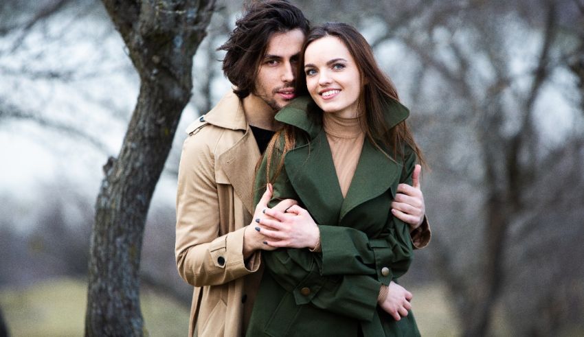 A man and woman hugging in a park.