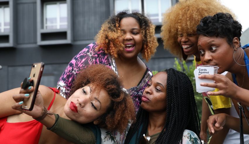 A group of women taking a selfie with a cell phone.