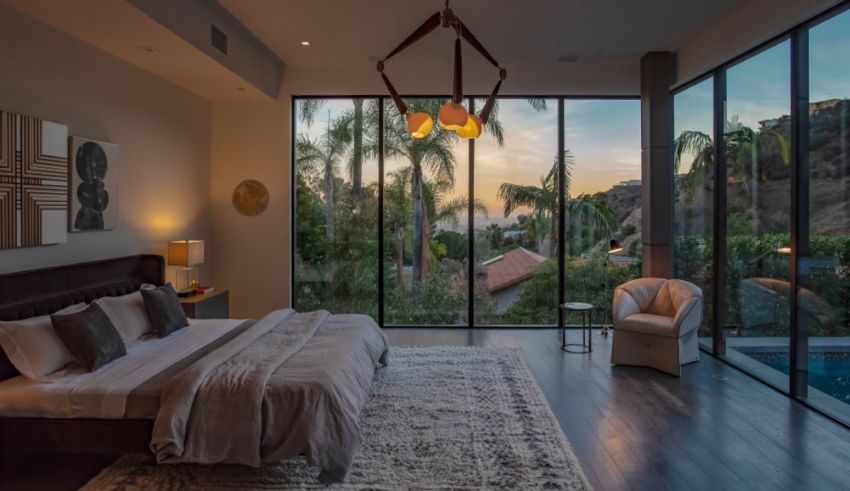 A bedroom with large windows overlooking the ocean.