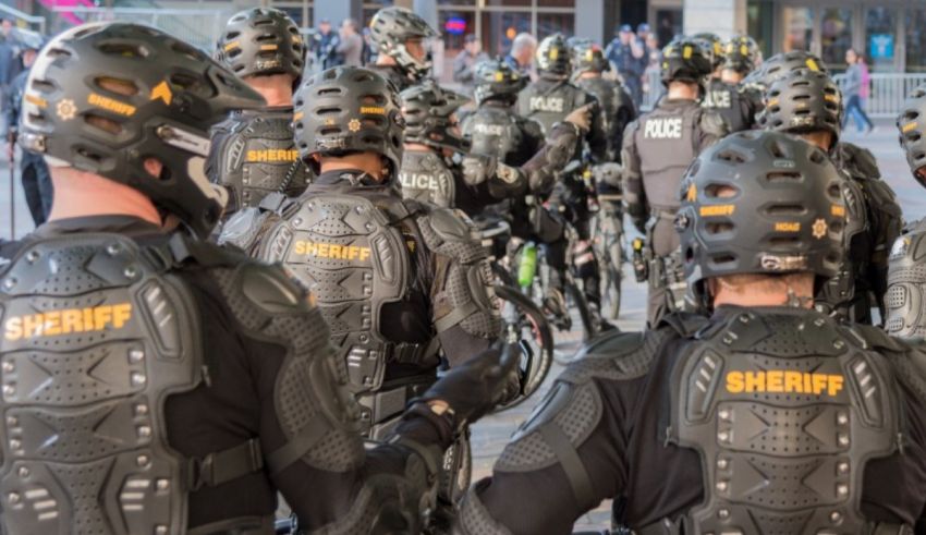 A group of sheriff's deputies standing on a sidewalk.