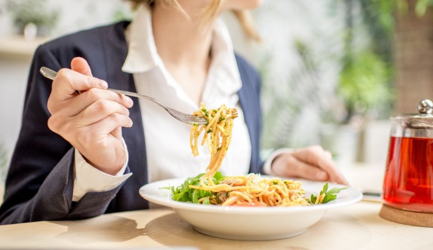 A woman is eating a bowl of spaghetti.
