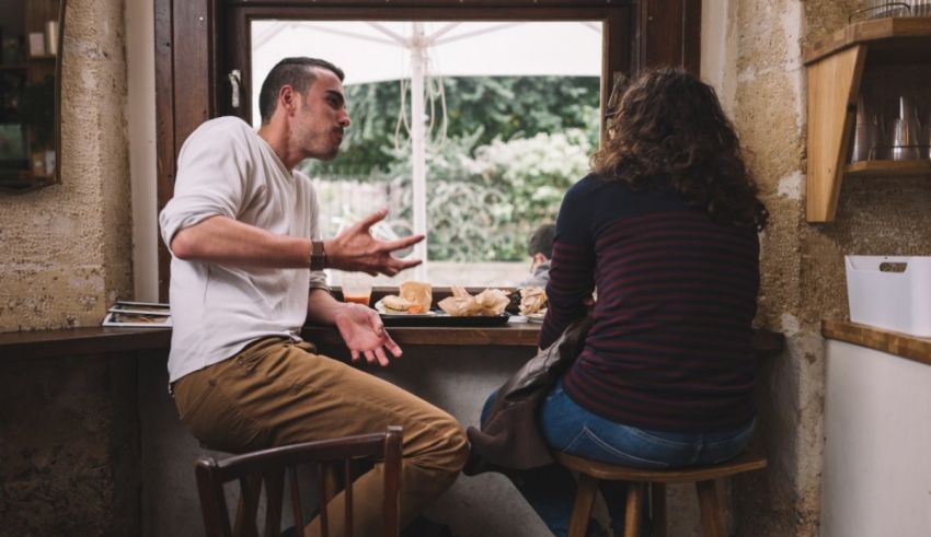 A man and woman sitting at a table with food.