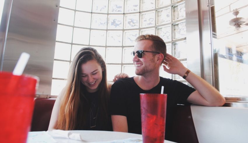 A man and woman sitting at a table in a diner.