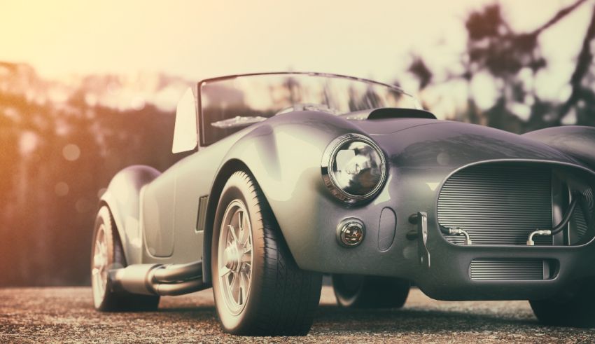 A silver sports car is parked on a dirt road.