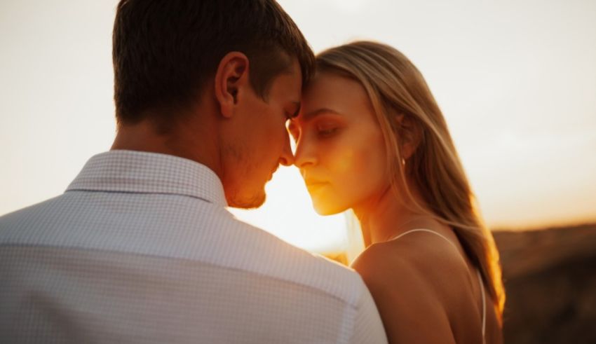 A man and woman are embracing at sunset.