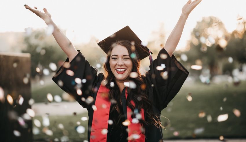 A woman in a graduation gown throwing confetti.