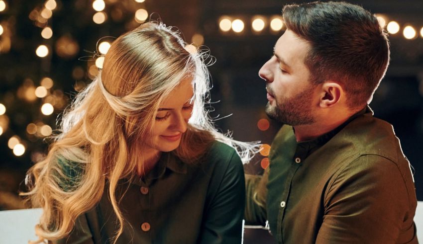 A man and woman looking at each other in front of a christmas tree.