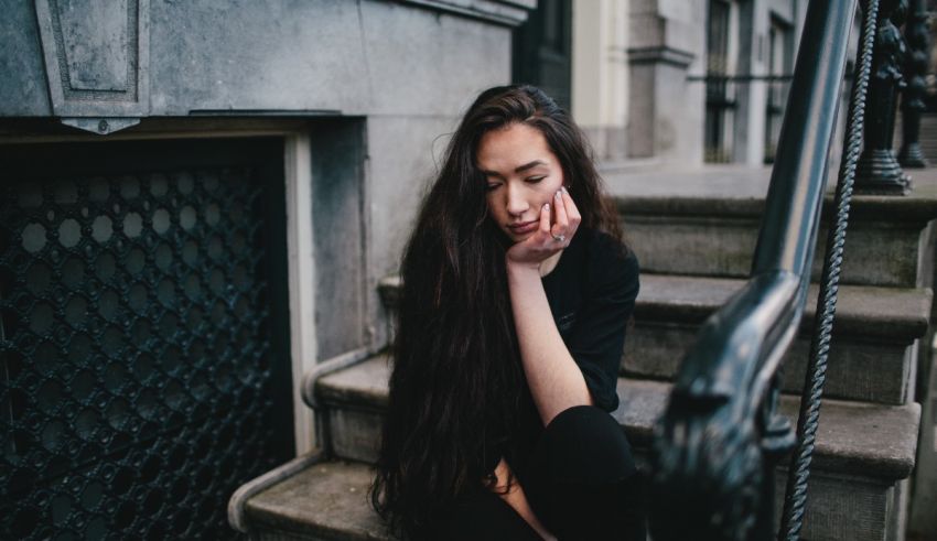 A woman sitting on the steps of a building.