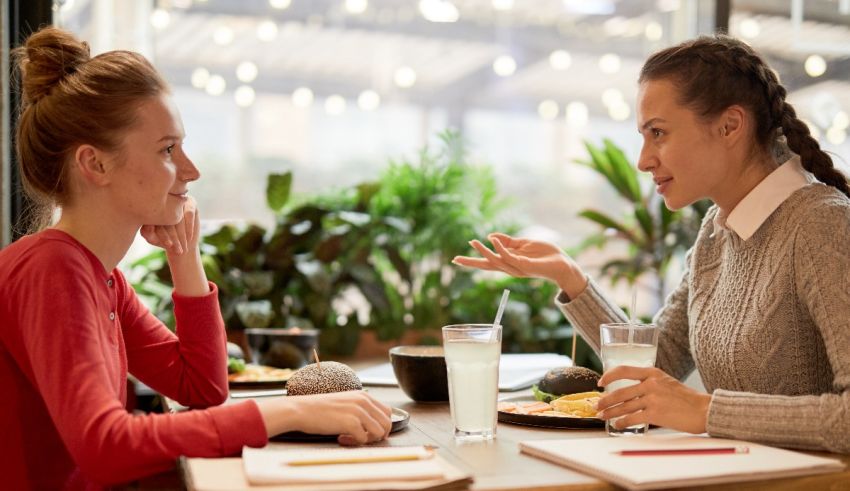 Two women talking at a table in a restaurant.