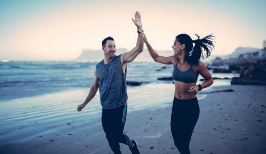 A man and woman running on the beach.