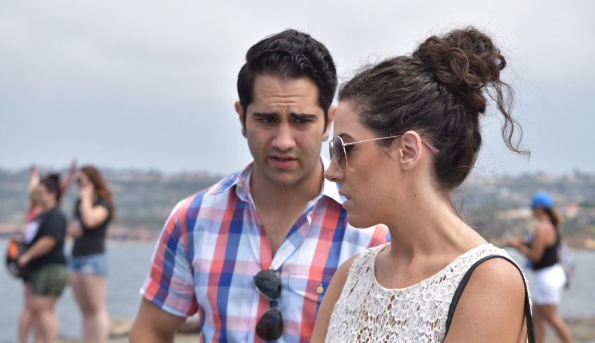 A man and woman standing next to each other on a beach.