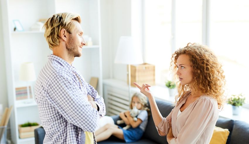A man and woman talking in a living room.
