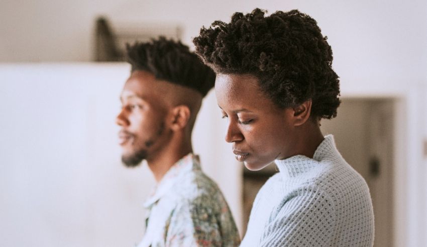 A black man and woman looking at each other in the kitchen.