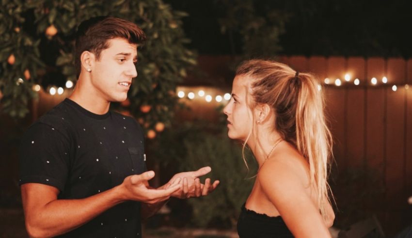 A man and a woman talking to each other in a backyard.