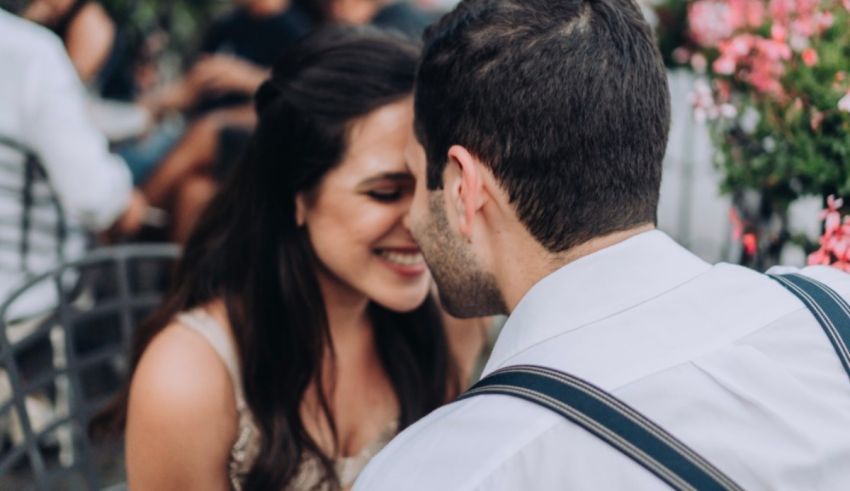 A man and woman sharing a kiss at a restaurant.