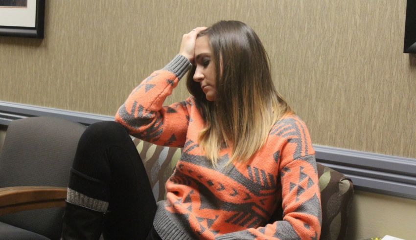 A woman sitting on a chair in a waiting room.