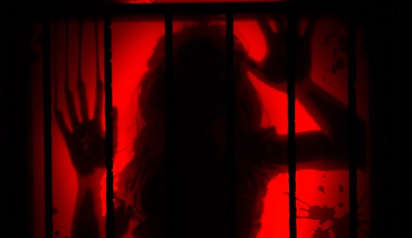 A shadow of a person behind bars.