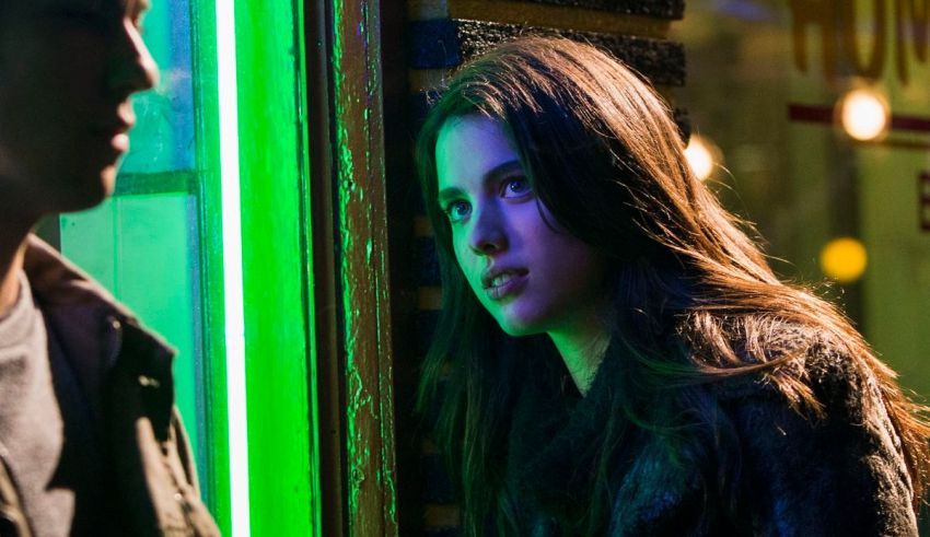 A man and a woman standing in front of a neon sign.