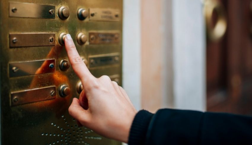 A person pressing a button on an elevator door.