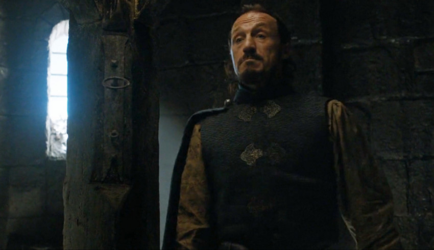 A man in a medieval costume is standing in a dark room.