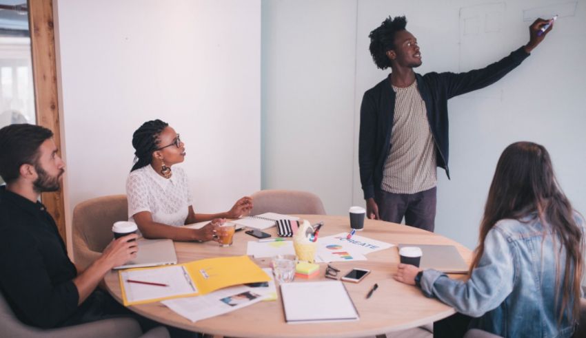 A group of people sitting around a table in a meeting room.