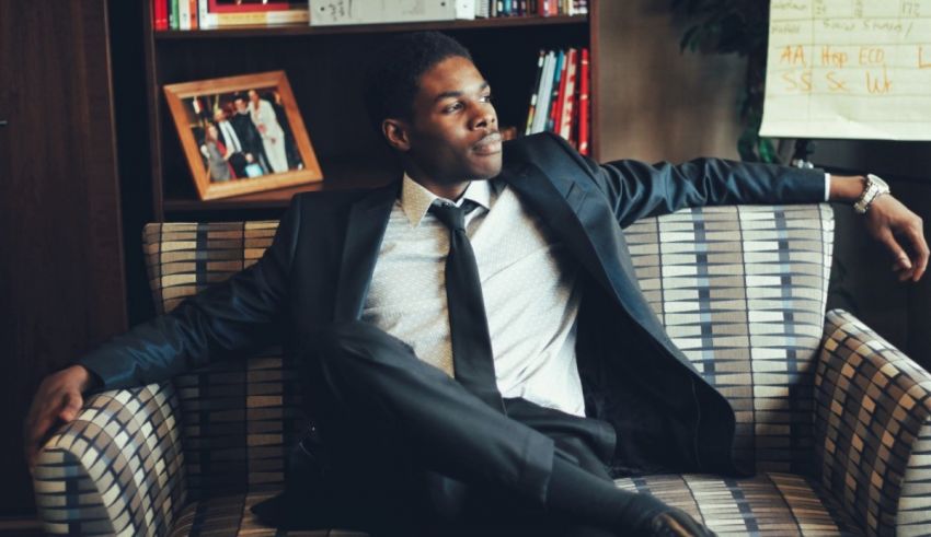 A man in a suit and tie sitting on a couch.