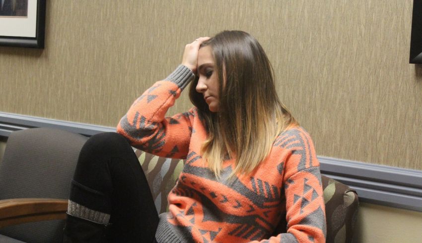 A woman sitting on a couch in a waiting room.