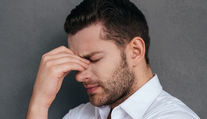 A man with a headache holding his hand to his face.