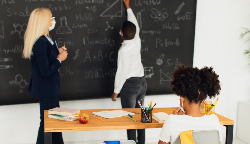 A group of people standing in front of a blackboard.