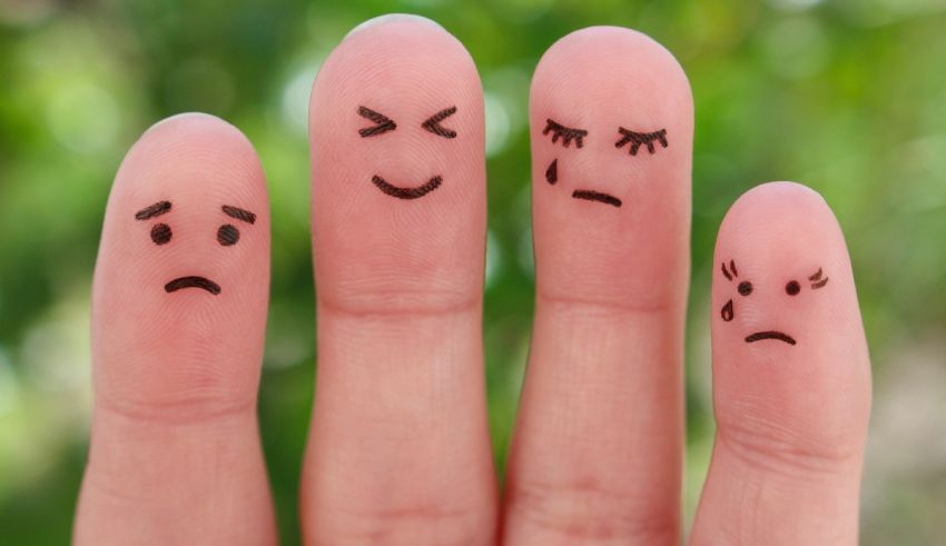 A person's fingers with different emotions drawn on them.