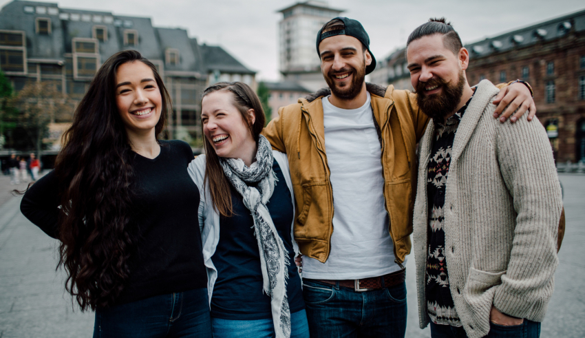 A group of people smiling in front of a building.