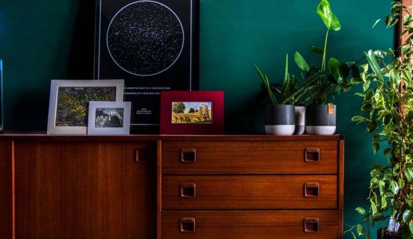 A living room with green walls and a wooden dresser.