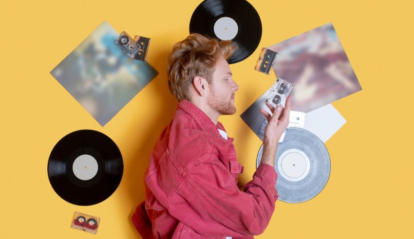 A man holding a record in front of a yellow wall.
