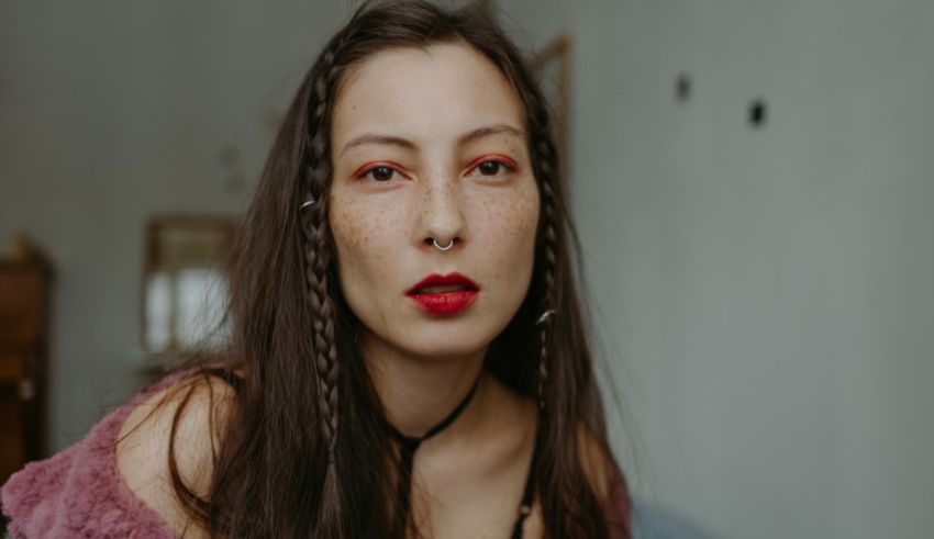 A young woman with freckles and red lipstick.