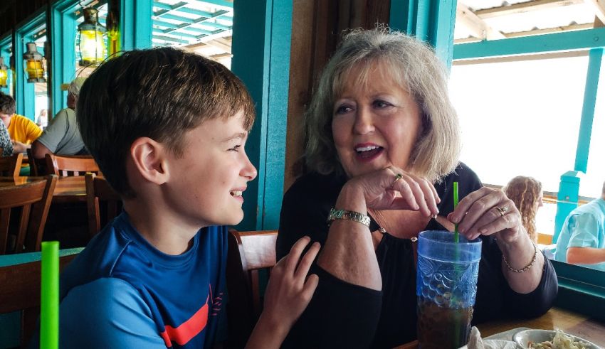 A woman and a boy sitting at a table in a restaurant.