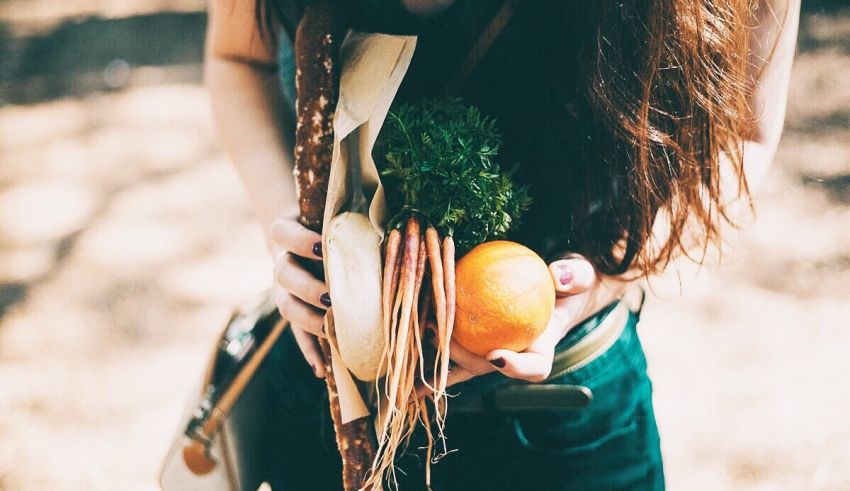 A woman holding a bunch of vegetables in her hands.
