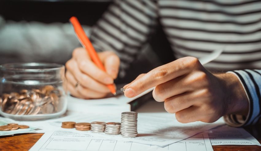 A person is putting money into a pile of coins.